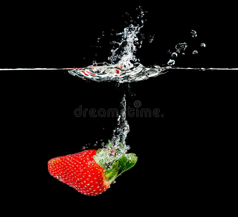 Fragola fresca che cade nell'acqua fotografia stock libera da diritti Fragola fresca che cade nell'acqua fotografia stock libera da diritti