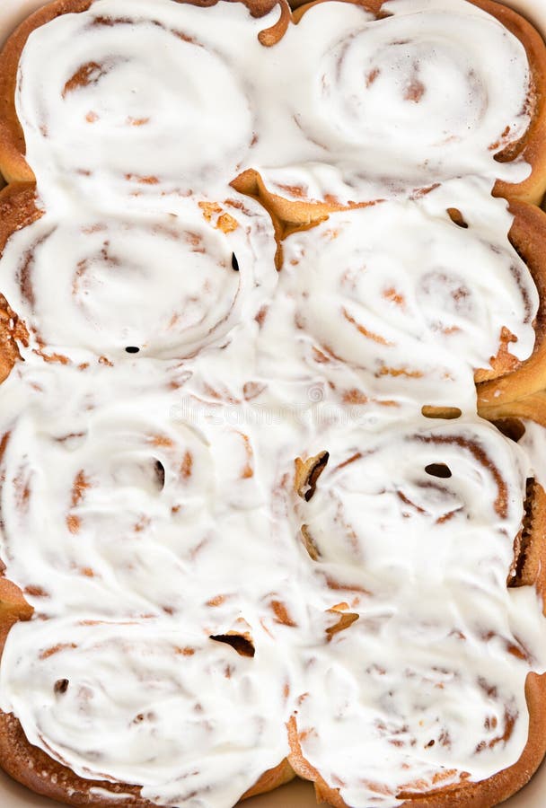 Fragrant freshly baked Cinnamon rolls or cinnabons with white cream glaze. Cinnabons recipe. Traditional homemade sweet buns. stock photo Fragrant freshly baked Cinnamon rolls or cinnabons with white cream glaze. Cinnabons recipe. Traditional homemade sweet buns. stock photo