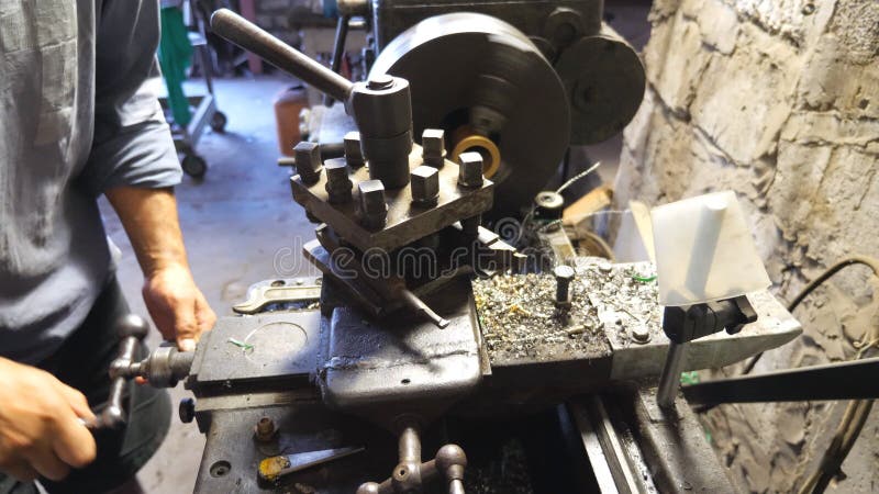 Fraiseuse haute ou étroite dans l'action. Turner méconnaissable travaillant avec le vieil établi dans son garage ou atelier