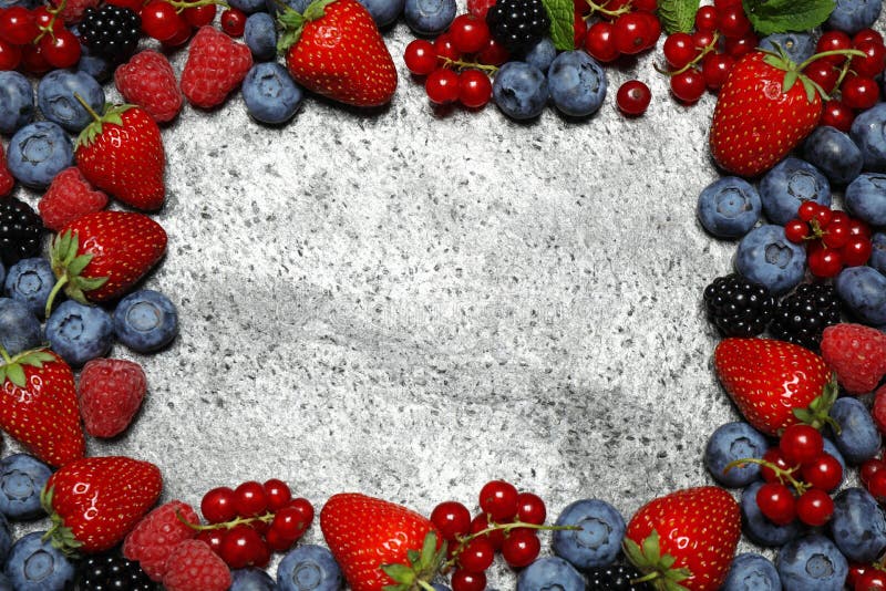 Frame of different fresh berries on grey background, top view. Space for text royalty free stock image