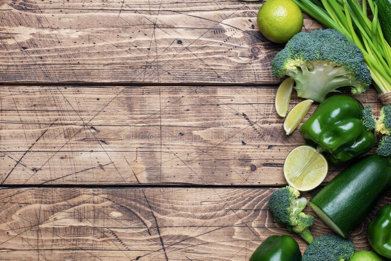 Frame Fresh green vegetables and herbs on a wooden background. Copy space. stock photos