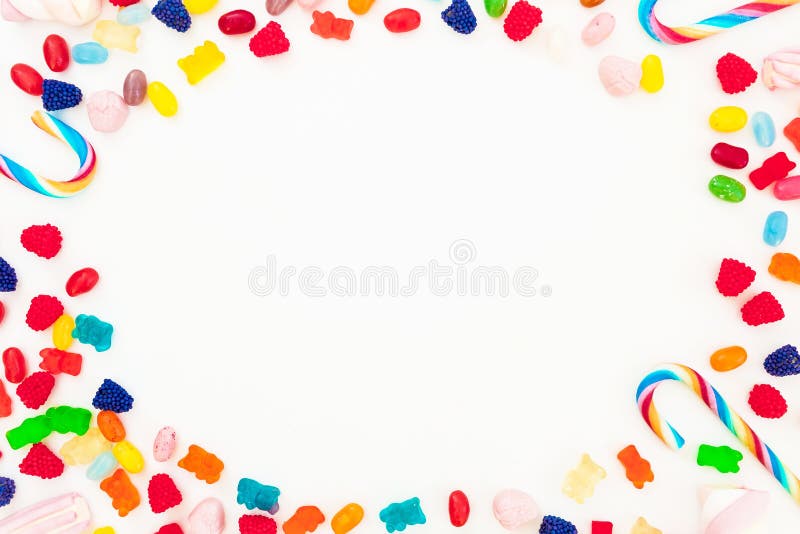 Frame made of bright candy, marmalade and candy canes on white background. Flat lay, top view. Unhealthy food