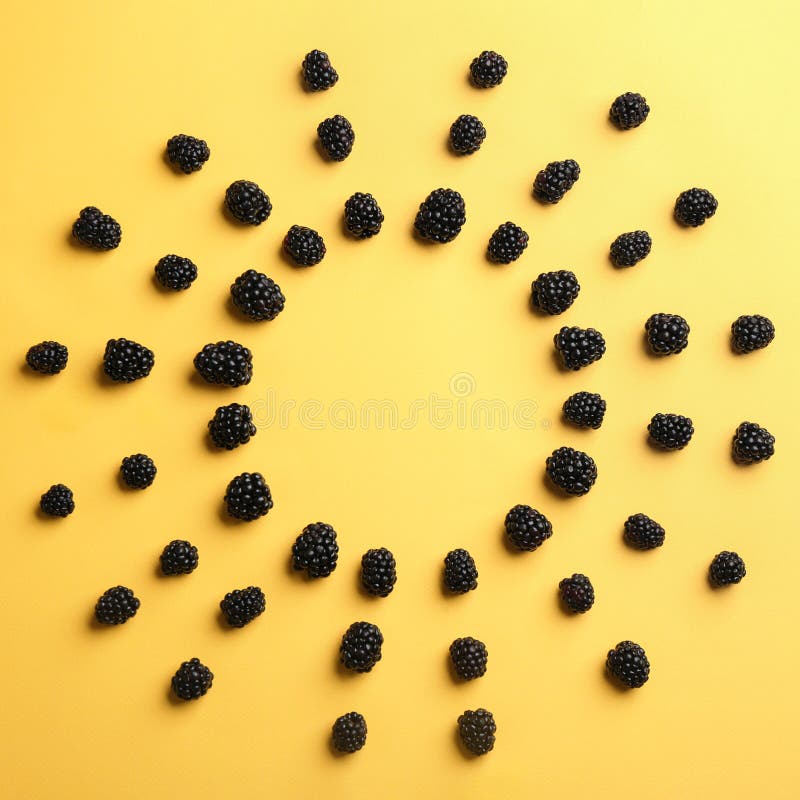 Frame made with fresh blackberries on yellow background, top view. stock photography