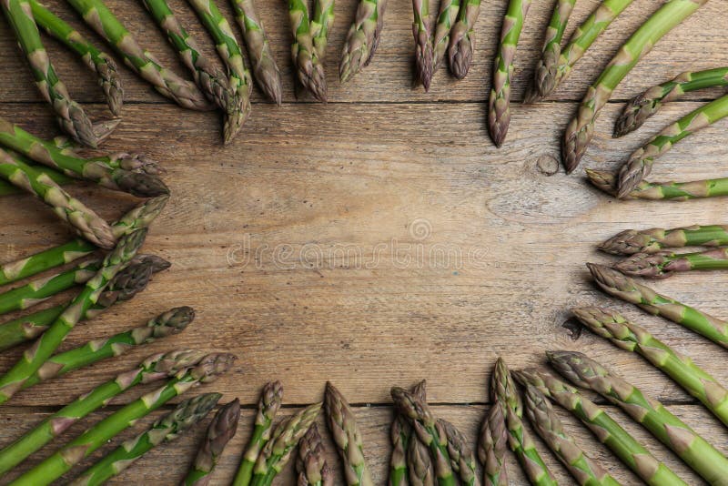 Frame made with fresh raw asparagus on table, flat lay. Space for text royalty free stock photos