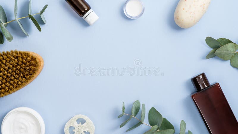 Frame made of organic spa cosmetics and accessories on blue background. Flat lay, top view, copy space. Zero waste bathroom