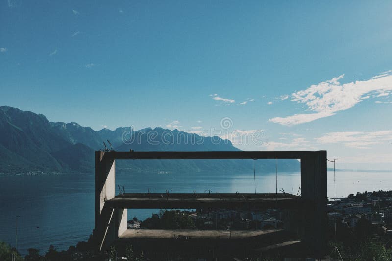 Frame of unfinished building in front of Lake Geneva.