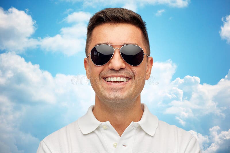 Framsida av att le mannen i solglasögon över blå himmel royaltyfri fotografi Framsida av att le mannen i solglasögon över blå himmel royaltyfri fotografi
