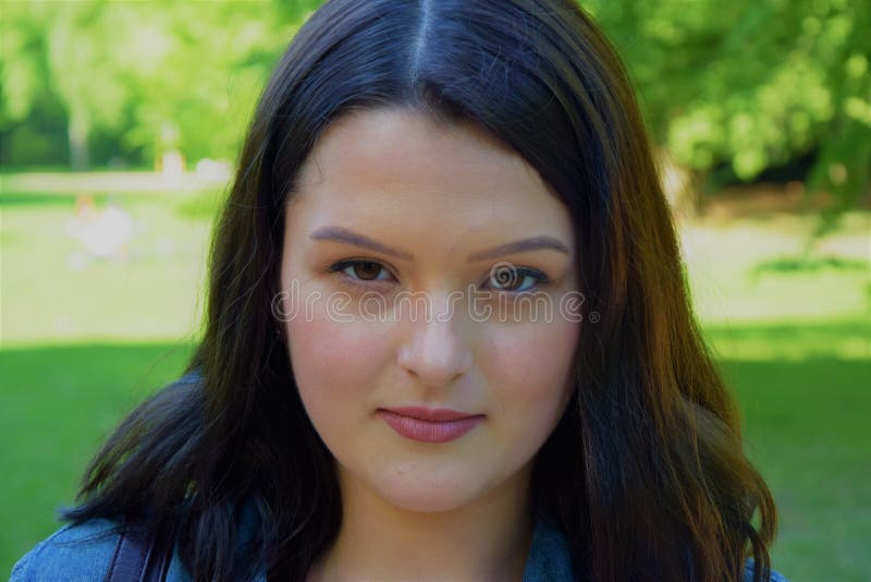 Framsida av en ung vällustig flicka i bakgrunden av parkera arkivfoto Framsida av en ung vällustig flicka i bakgrunden av parkera arkivfoto