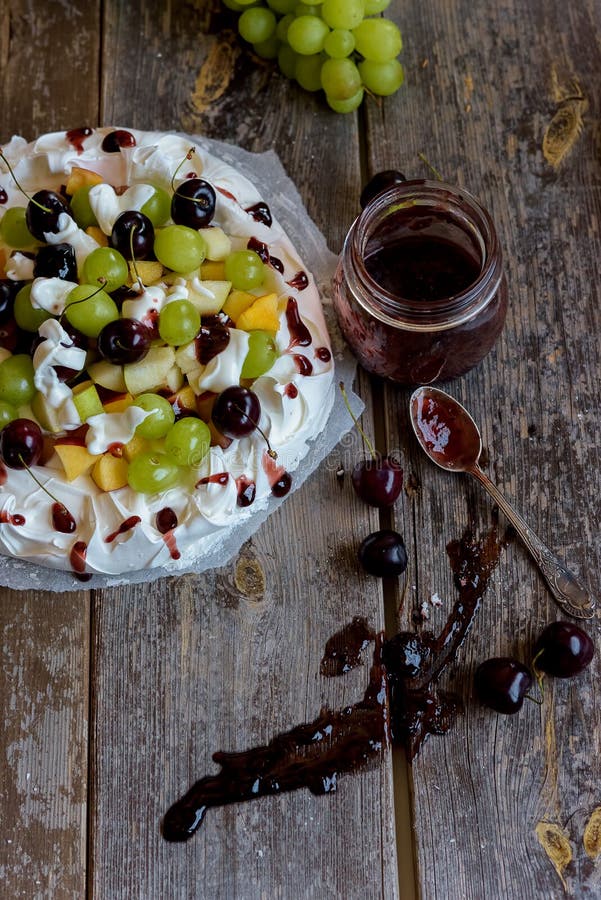Framställning av en Pavlova efterrätt med frukt och driftstopp royaltyfri fotografi Framställning av en Pavlova efterrätt med frukt och driftstopp royaltyfri fotografi