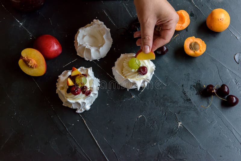Framställning av en Pavlova efterrätt med frukt och driftstopp royaltyfria bilder Framställning av en Pavlova efterrätt med frukt och driftstopp royaltyfria bilder