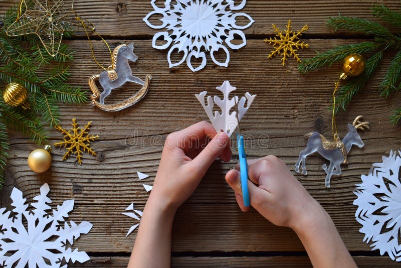 Making paper snowflakes with your own hands. Children& x27;s DIY. Merry Christmas and New Year concept. Step 2. Cut the snowflake. Making paper snowflakes with your own hands. Children& x27;s DIY. Merry Christmas and New Year concept. Step 2. Cut the snowflake