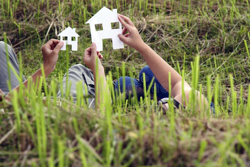 A couple holding cut-outs of house outlines as they envisioned their future home together with copy space. A couple holding cut-outs of house outlines as they envisioned their future home together with copy space