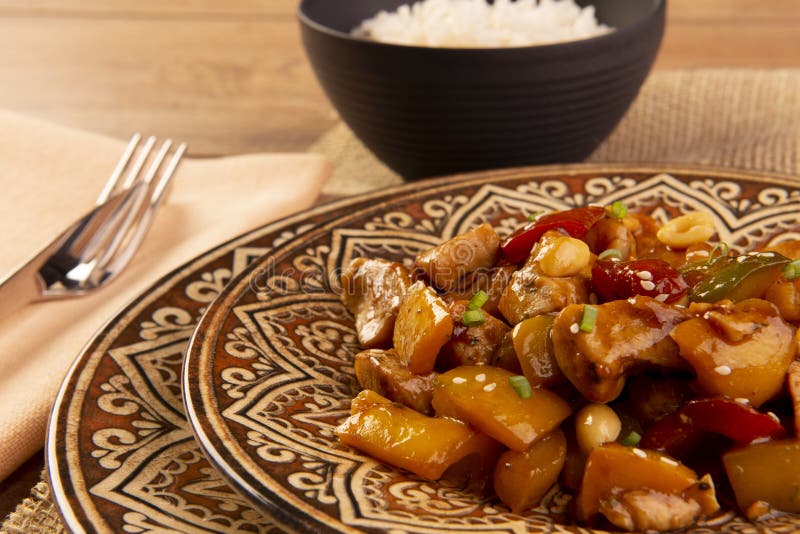 Frango de xadrez em prato verde sobre fundo de madeira - comida chinesa.