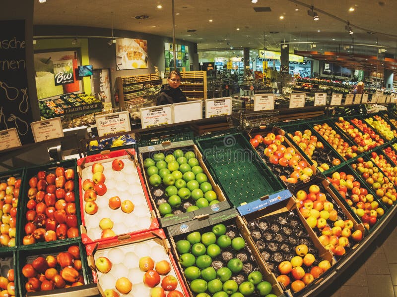 Woman shopping apples varieties in German city supermarket