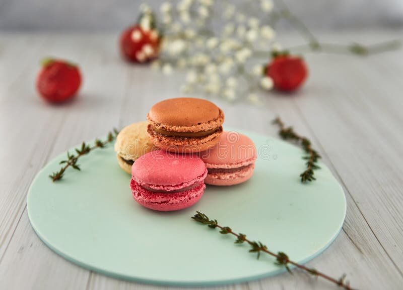 Franska f?rgrika makron F?rgrika pastellf?rgade makron p? en ljus bakgrund med nya jordgubbar arkivfoto Franska f?rgrika makron F?rgrika pastellf?rgade makron p? en ljus bakgrund med nya jordgubbar arkivfoto