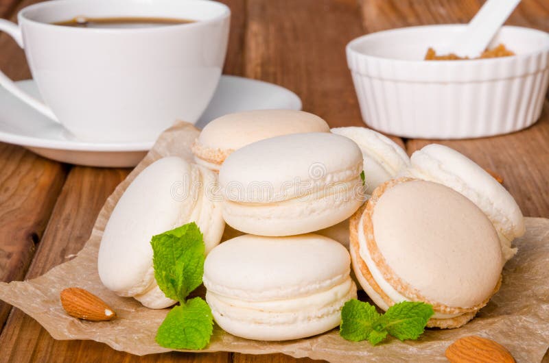 Franska traditionella efterrättmacarons med vanilj och vit chokladpralin arkivbild Franska traditionella efterrättmacarons med vanilj och vit chokladpralin arkivbild