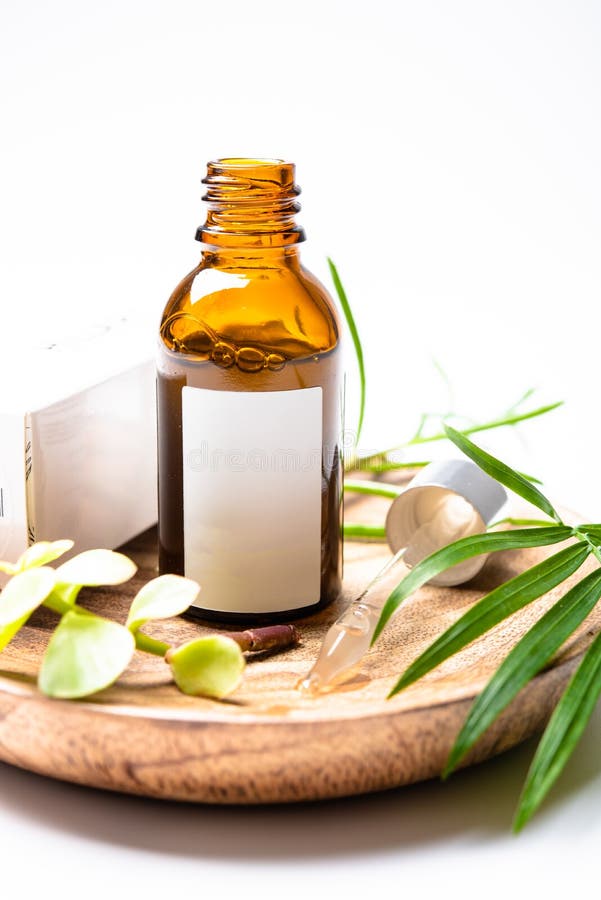 Frasco cosmético de vidrio marrón maquillaje con etiqueta blanca en blanco y hojas verdes, envase sérico imagen de archivo Frasco cosmético de vidrio marrón maquillaje con etiqueta blanca en blanco y hojas verdes, envase sérico imagen de archivo