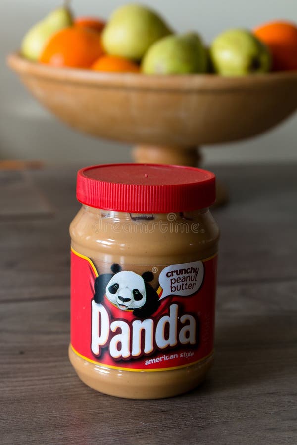 Frasco da manteiga de amendoim da panda sobre uma tabela de madeira com fruto saudável no fundo imagens de stock Frasco da manteiga de amendoim da panda sobre uma tabela de madeira com fruto saudável no fundo imagens de stock