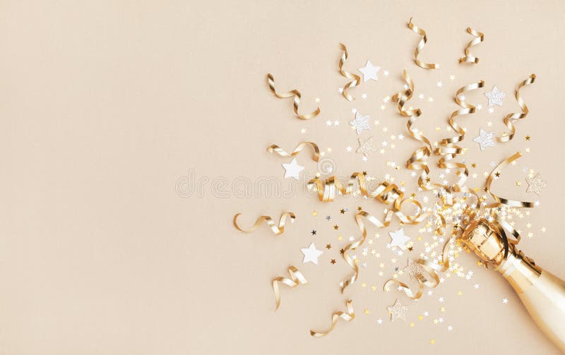 Champagne bottle with confetti stars and party streamers on gold festive background. Christmas, birthday or wedding concept. Flat lay. Champagne bottle with confetti stars and party streamers on gold festive background. Christmas, birthday or wedding concept. Flat lay
