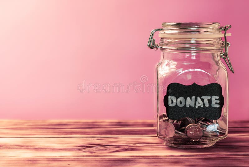 Frasco de vidrio con monedas con etiqueta de tiza donada sobre fondo rosa. concepto de donación y caridad. espacio de copia