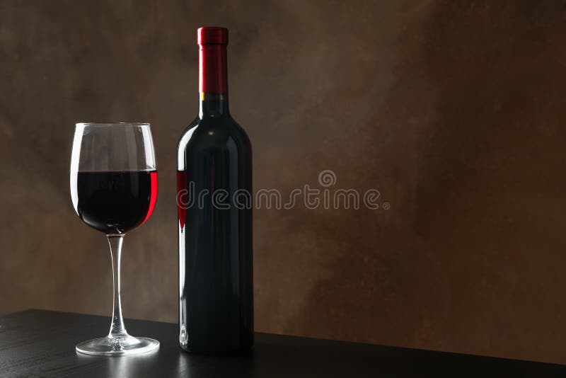 Frasco y vaso con vino de fondo marrón imagen de archivo libre de regalías Frasco y vaso con vino de fondo marrón imagen de archivo libre de regalías