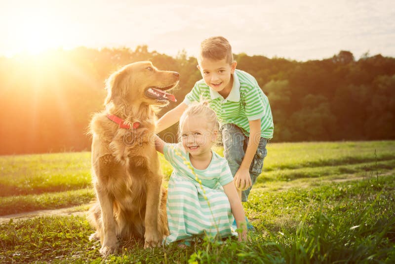 Fratello adorabile e sorella che giocano con il loro cane immagini stock Fratello adorabile e sorella che giocano con il loro cane immagini stock