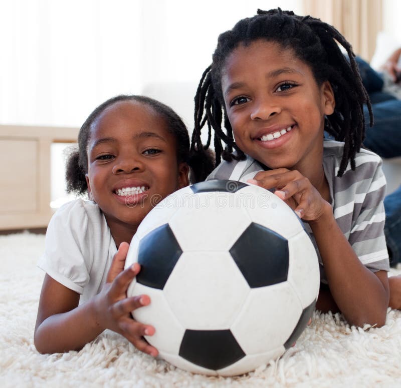 Fratello e sorella africani con una sfera di calcio immagini stock libere da diritti Fratello e sorella africani con una sfera di calcio immagini stock libere da diritti