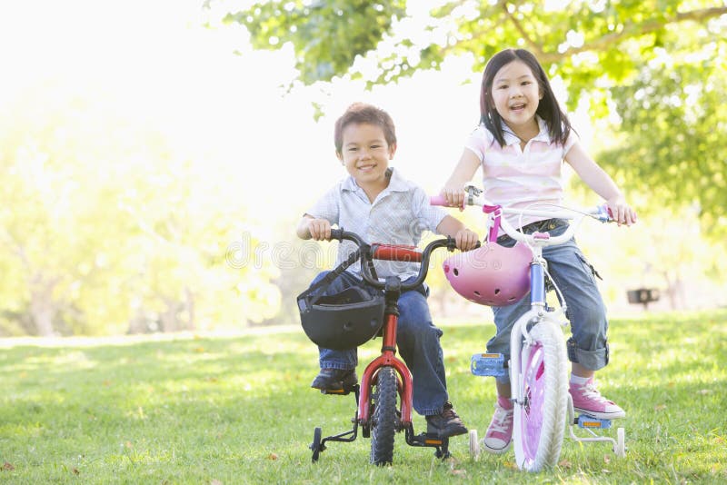 Fratello e sorella all'aperto sul sorridere delle biciclette
