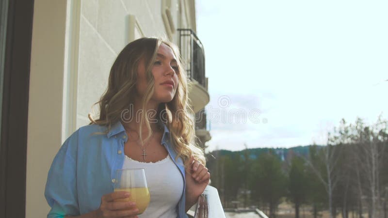 Frau auf dem Balkon am frühen Morgen und Orangensaft der Getränke