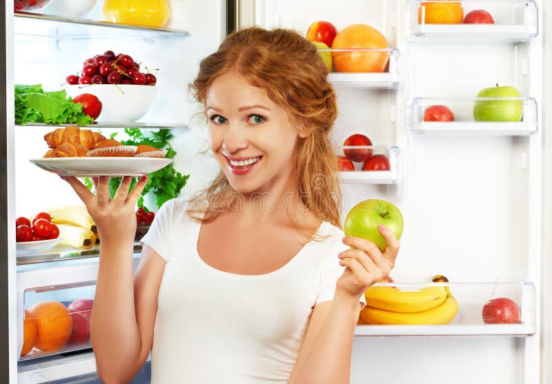 Frau auf der Diät, zum zwischen gesundem und ungesundem Lebensmittel nahe zu wählen lizenzfreies stockbild Frau auf der Diät, zum zwischen gesundem und ungesundem Lebensmittel nahe zu wählen lizenzfreies stockbild