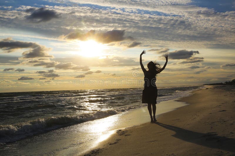 Frau auf der Seeküste auf Sonnenuntergang stockfoto