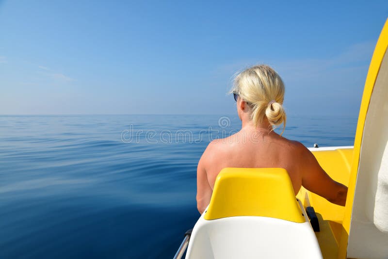 Frau auf einem Tretboot auf Wasserspiegel am sonnigen Tag lizenzfreies stockbild Frau auf einem Tretboot auf Wasserspiegel am sonnigen Tag lizenzfreies stockbild