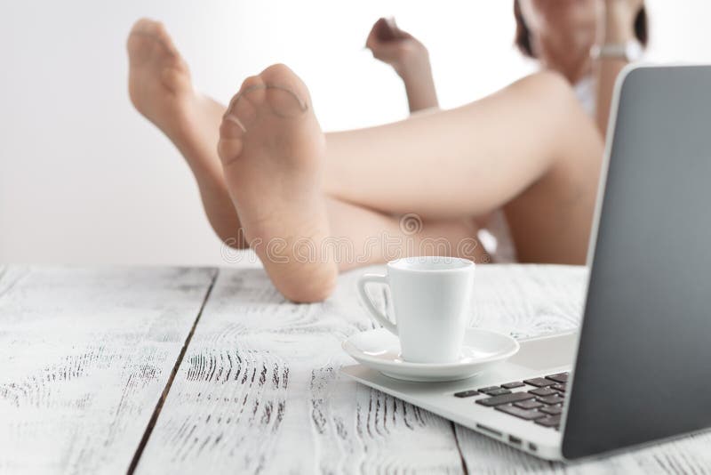 Frau benutzt ihren Laptop zu Hause in ihrem Wohnzimmer Wile talkin lizenzfreies stockbild Frau benutzt ihren Laptop zu Hause in ihrem Wohnzimmer Wile talkin lizenzfreies stockbild