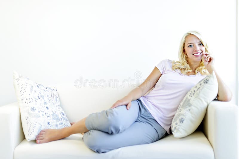 Frau, die auf Couch sich entspannt