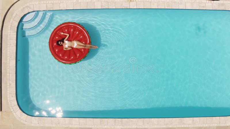 Frau, die auf einer Matratze im Pool liegt