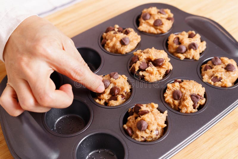 Frau, die Backschokoladechipmuffin zubereitet lizenzfreie stockfotos Frau, die Backschokoladechipmuffin zubereitet lizenzfreie stockfotos