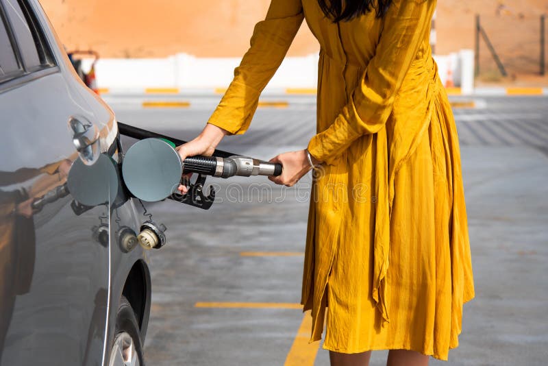 Frau, die Brennstoff auf der Tankstelle hinzufügt lizenzfreies stockbild Frau, die Brennstoff auf der Tankstelle hinzufügt lizenzfreies stockbild