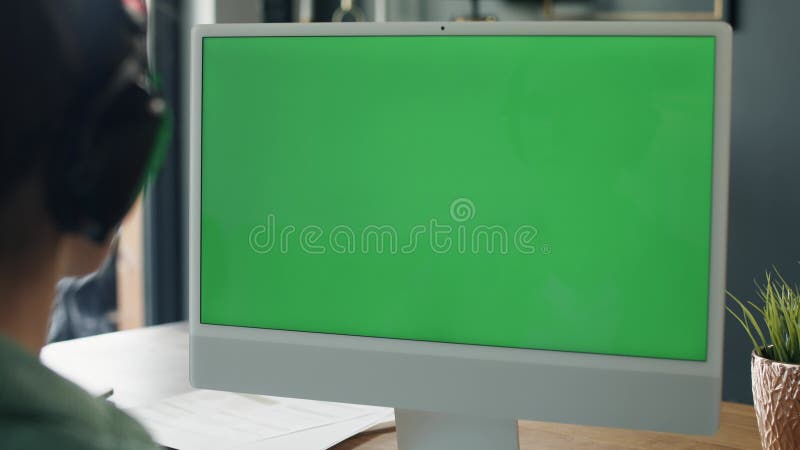 Frau, die am Computer mit grünem Bildschirm arbeitet