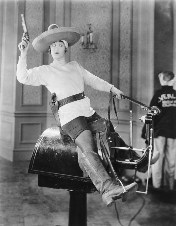 Frau, die Cowgirl auf Riemenscheibe spielt stockbilder Frau, die Cowgirl auf Riemenscheibe spielt stockbilder