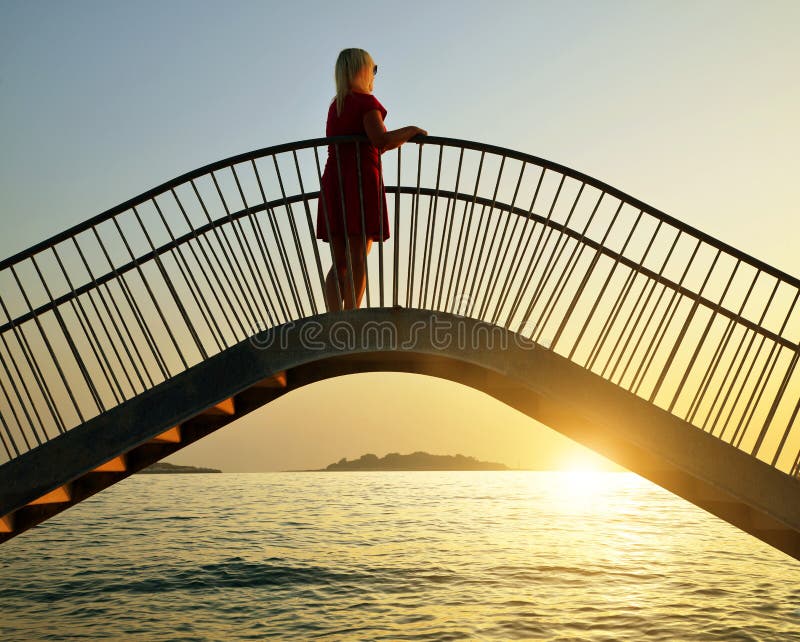 Frau, die das Meer bei Sonnenuntergang aufpasst lizenzfreie stockfotos Frau, die das Meer bei Sonnenuntergang aufpasst lizenzfreie stockfotos