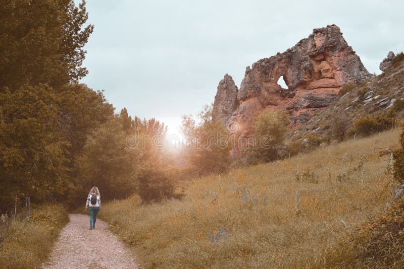 Frau, die durch eine Spur bei Sonnenuntergang geht stockfoto Frau, die durch eine Spur bei Sonnenuntergang geht stockfoto