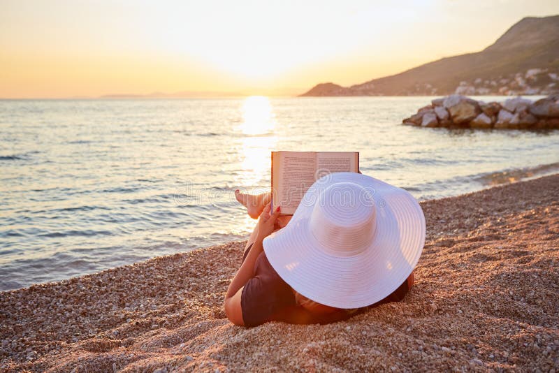 Frau, die ein Buch auf dem Strand liest Flach tief vom Fokus stockfotos Frau, die ein Buch auf dem Strand liest Flach tief vom Fokus stockfotos