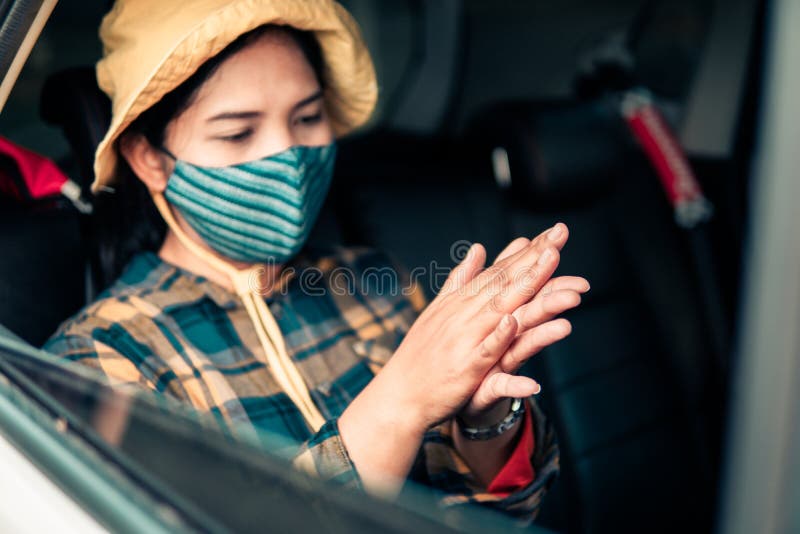 Frau, die eine Hand mit Gel Alkohol 75 vor dem Fahren durch die Screening, um zu verhindern, dass Coronavirus säubert