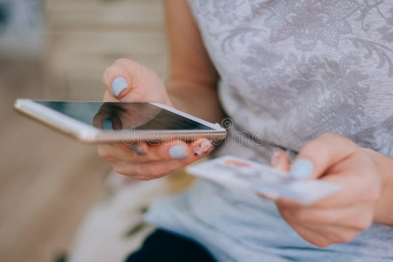Frau, die eine Kreditkarte hält und Handy für das on-line-Einkaufen verwendet lizenzfreies stockfoto Frau, die eine Kreditkarte hält und Handy für das on-line-Einkaufen verwendet lizenzfreies stockfoto