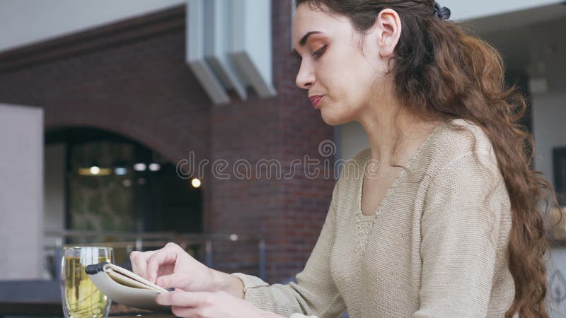 Frau, die eine Skizze am Café zeichnet