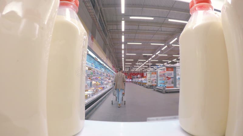 Frau, die frische Milch am Supermarkt kauft