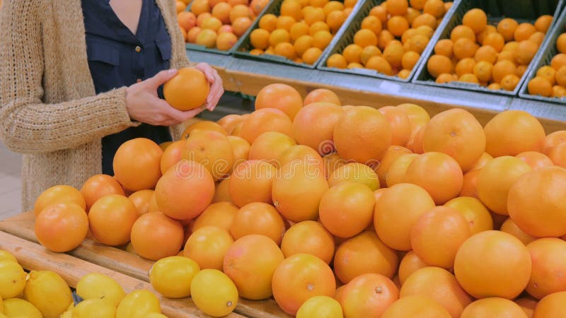 Frau, die frische Pampelmusen am Gemischtwarenladen kauft