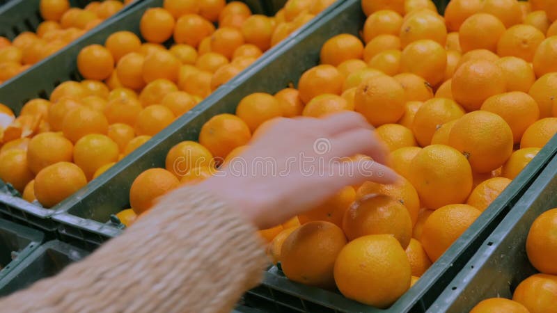 Frau, die frische Tangerinen am Gemischtwarenladen kauft