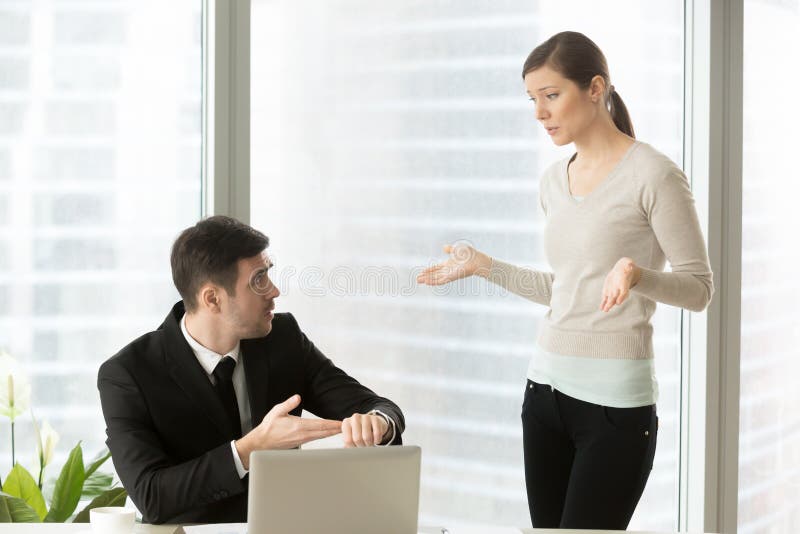 Company leader pointing on wrist watch when asking female employee about delay in project, fail deadline, deviation from schedule, late for work. Woman making excuses because of absence from work. Company leader pointing on wrist watch when asking female employee about delay in project, fail deadline, deviation from schedule, late for work. Woman making excuses because of absence from work