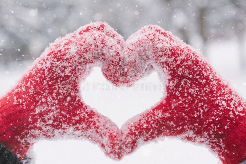 Frau, die Herzsymbol mit den schneebedeckten Händen macht stockfoto Frau, die Herzsymbol mit den schneebedeckten Händen macht stockfoto